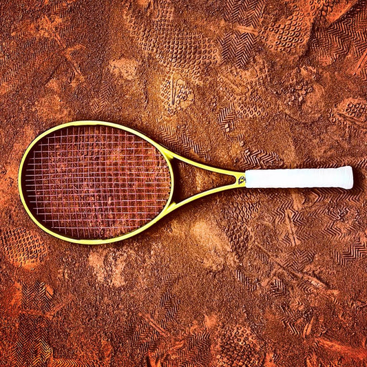 GOLDEN HOUR Sabrhero tennis racket on a clay court floor